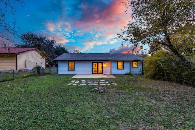 rear view of property featuring a yard, a patio, and fence