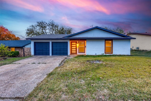 view of front of property with a garage, brick siding, concrete driveway, and a yard