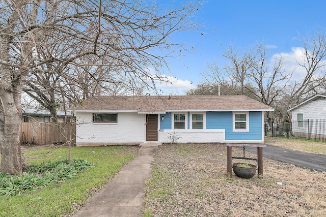 view of front of home featuring fence and a shingled roof