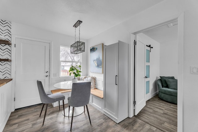 2905 Rogge Ln, Austin, TX 78723 - dining room featuring wood finished floors, a chandelier, and a barn door