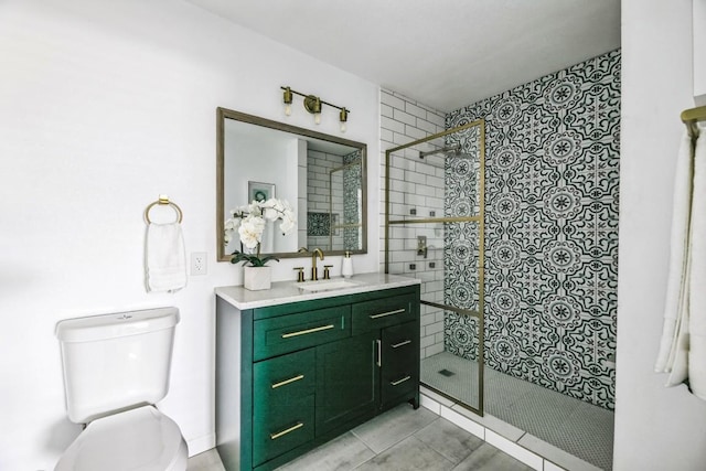 full bathroom featuring tiled shower, vanity, and toilet