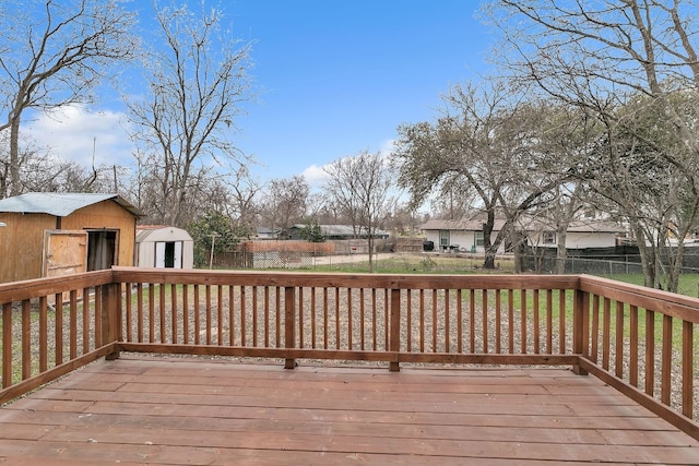 wooden terrace featuring a storage shed, a fenced backyard, and an outdoor structure