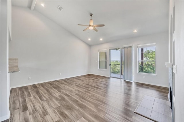 interior space with baseboards, visible vents, ceiling fan, wood finished floors, and vaulted ceiling with beams