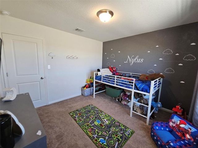 carpeted bedroom featuring a textured ceiling, visible vents, and baseboards