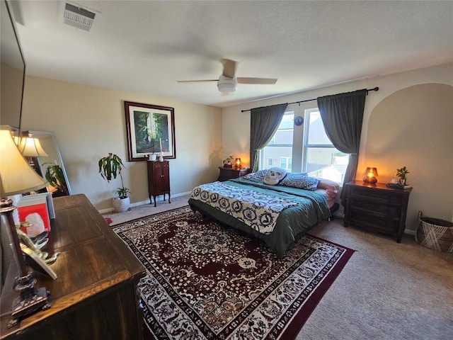 carpeted bedroom featuring baseboards, visible vents, and ceiling fan