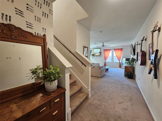 staircase with a ceiling fan, carpet, and baseboards