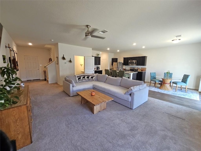 carpeted living room featuring a ceiling fan, recessed lighting, and visible vents