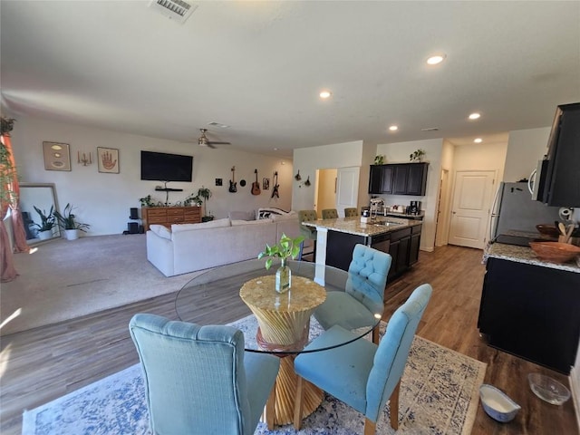 dining room featuring a ceiling fan, wood finished floors, visible vents, and recessed lighting