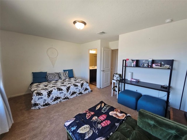 bedroom with carpet floors, visible vents, and connected bathroom