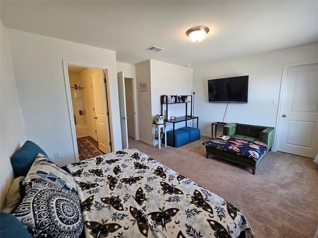 carpeted bedroom with visible vents, a textured ceiling, and ensuite bathroom