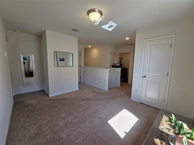 spare room with baseboards, visible vents, and light colored carpet