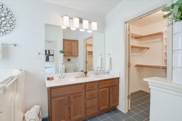 bathroom with a sink, a spacious closet, toilet, and double vanity