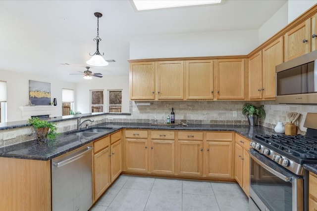 kitchen with stainless steel appliances, a sink, decorative light fixtures, and decorative backsplash