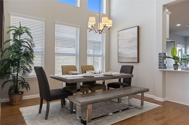 dining space featuring an inviting chandelier, baseboards, dark wood finished floors, and recessed lighting