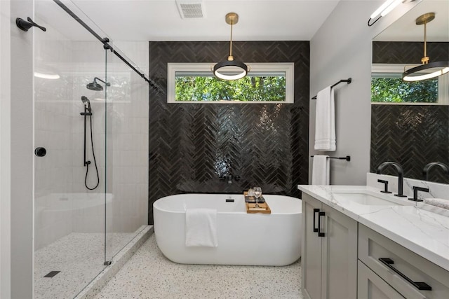 bathroom with visible vents, a soaking tub, speckled floor, vanity, and a shower stall