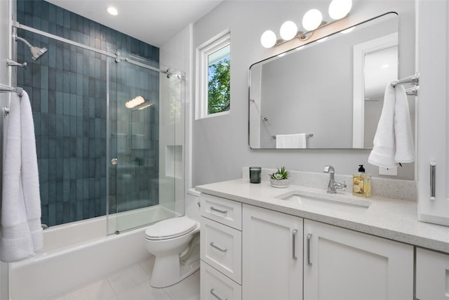 full bathroom featuring tile patterned flooring, vanity, toilet, and bath / shower combo with glass door