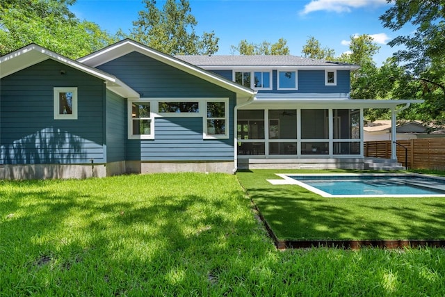 back of house with a lawn, fence, a sunroom, and an outdoor pool