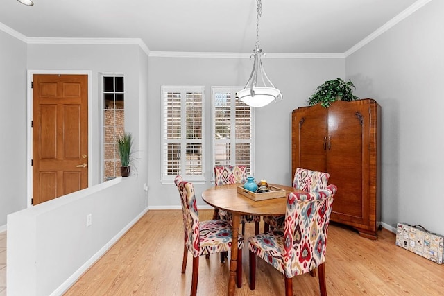 dining area with crown molding, light wood finished floors, and baseboards