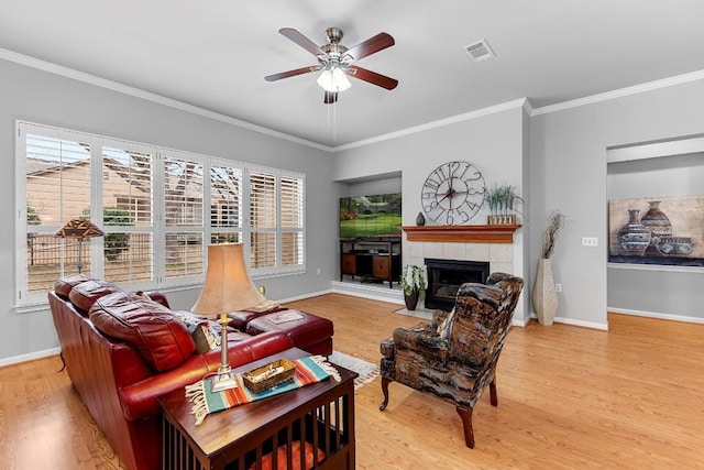 living area with baseboards, a fireplace, visible vents, and light wood finished floors