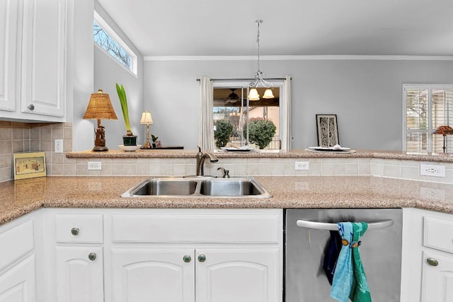 kitchen featuring pendant lighting, decorative backsplash, stainless steel dishwasher, white cabinets, and a sink