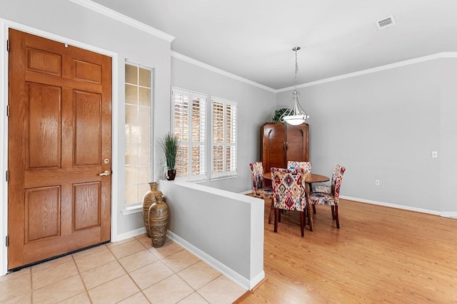 entrance foyer featuring light wood-style floors, baseboards, visible vents, and ornamental molding