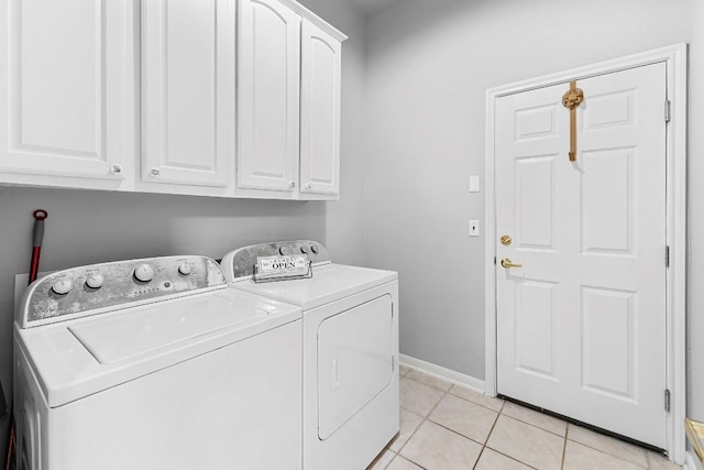 clothes washing area featuring cabinet space, washer and clothes dryer, baseboards, and light tile patterned flooring