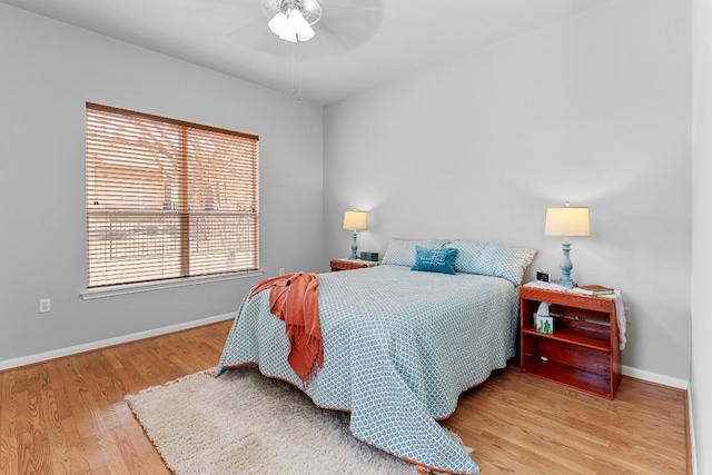 bedroom with a ceiling fan, baseboards, and wood finished floors