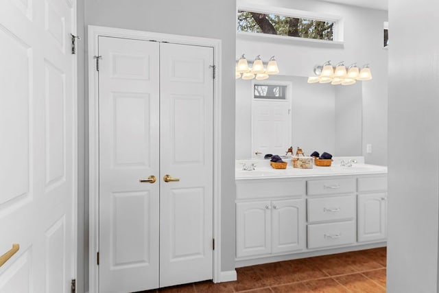 full bathroom with double vanity, a closet, a sink, and tile patterned floors