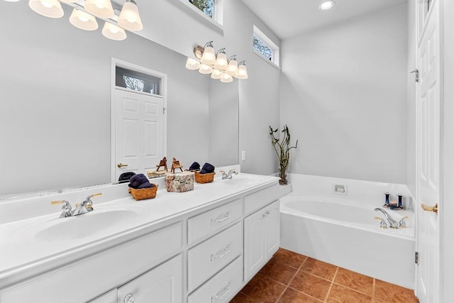 full bathroom with a bath, double vanity, a sink, and tile patterned floors