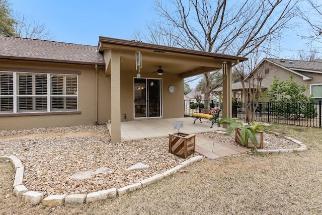 back of house with roof with shingles, a patio, stucco siding, a ceiling fan, and fence