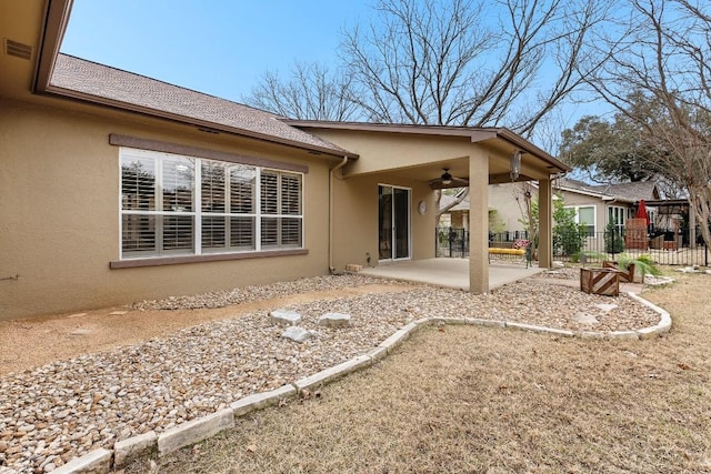 rear view of house featuring a patio area, fence, a ceiling fan, and stucco siding