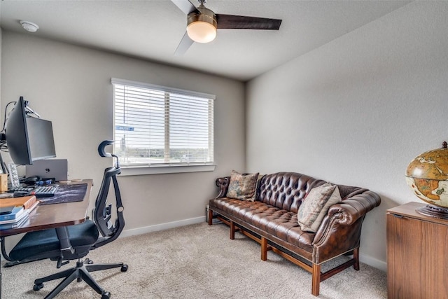 home office featuring light carpet, ceiling fan, and baseboards