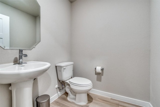 bathroom featuring wood finished floors, toilet, and baseboards