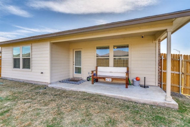 rear view of house with a patio, a yard, and fence