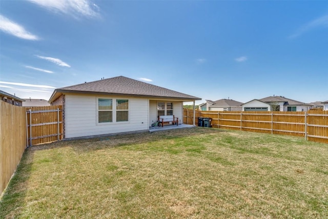 back of house featuring a yard, a patio area, and a fenced backyard