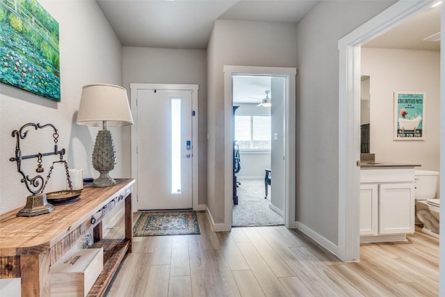 foyer with light wood-type flooring and baseboards