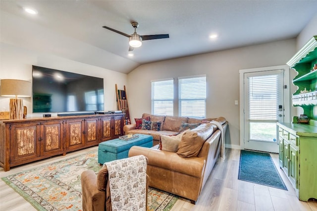 living area with lofted ceiling, baseboards, light wood-style flooring, and a ceiling fan