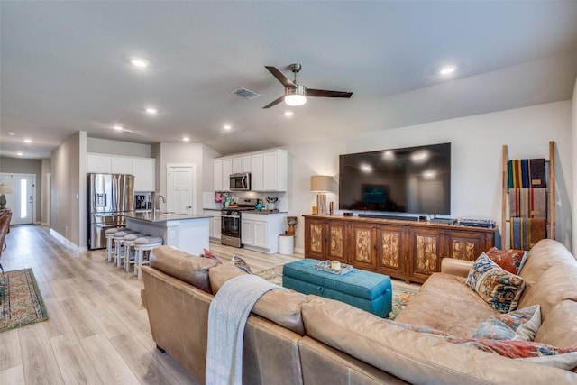 living room with recessed lighting, visible vents, ceiling fan, light wood-type flooring, and baseboards