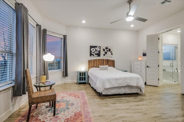 bedroom featuring visible vents, baseboards, light wood-style flooring, ensuite bathroom, and recessed lighting