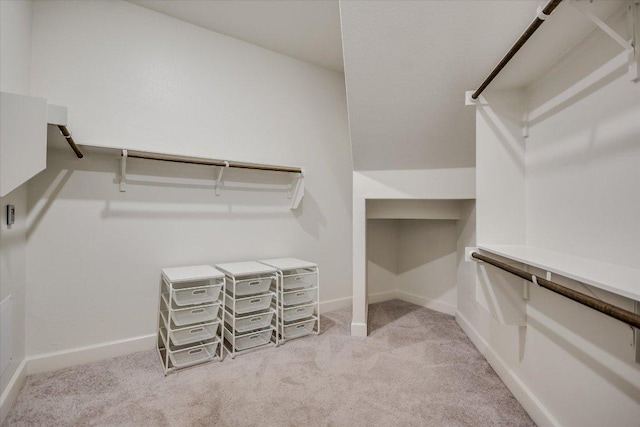 walk in closet featuring light colored carpet