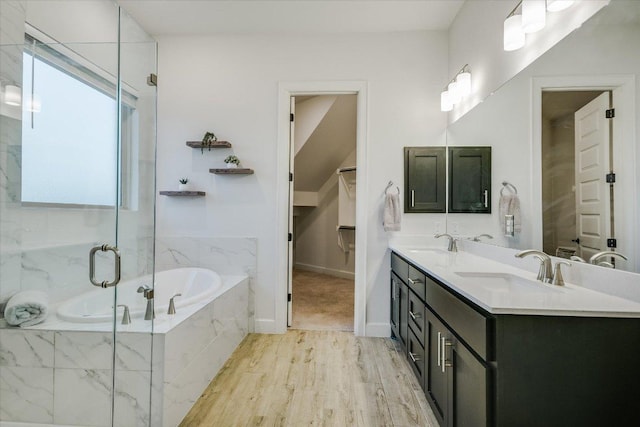 full bathroom featuring double vanity, a garden tub, a marble finish shower, and a sink