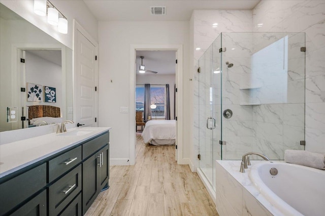 bathroom featuring a marble finish shower, visible vents, connected bathroom, vanity, and wood finished floors