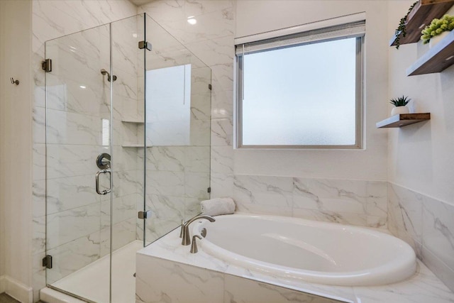 bathroom with a garden tub and a marble finish shower