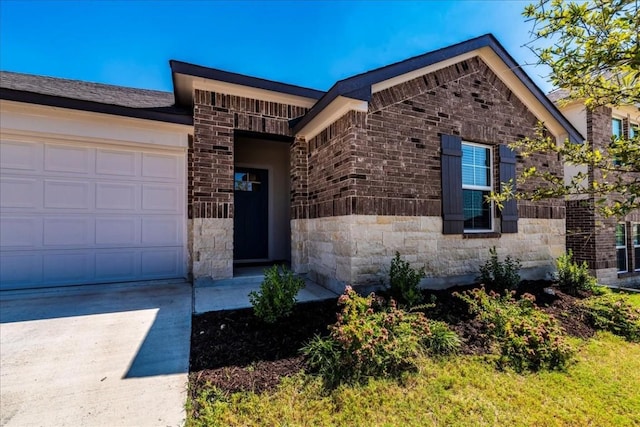 view of front of house featuring a garage, stone siding, brick siding, and concrete driveway