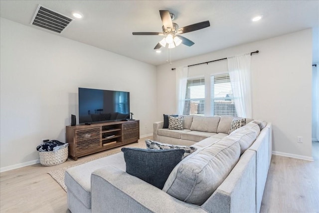 living area with wood finished floors, a ceiling fan, baseboards, and recessed lighting