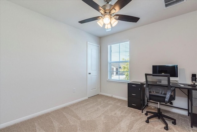 office space featuring light colored carpet, baseboards, and a ceiling fan