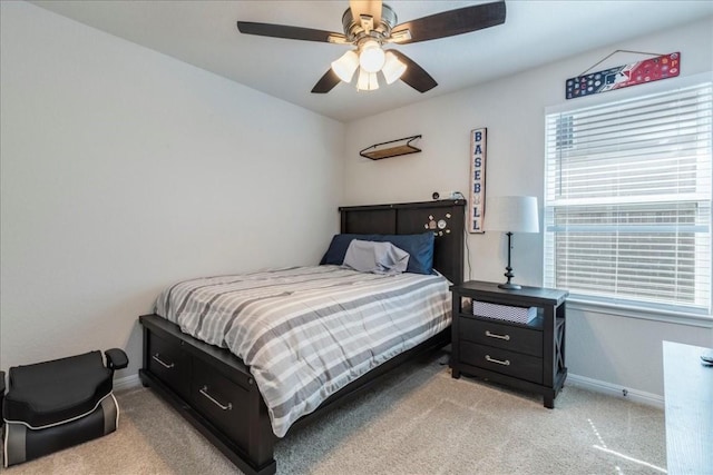 bedroom featuring light colored carpet, baseboards, and a ceiling fan