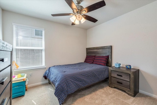 bedroom with light colored carpet, baseboards, and a ceiling fan