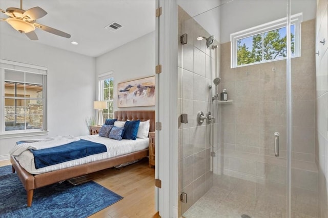 bedroom featuring a ceiling fan, visible vents, and light wood finished floors