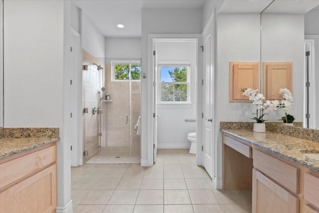 full bathroom featuring tile patterned flooring, toilet, vanity, baseboards, and a stall shower